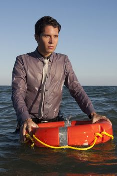 Business man holds a lifesaver buoy on the water.