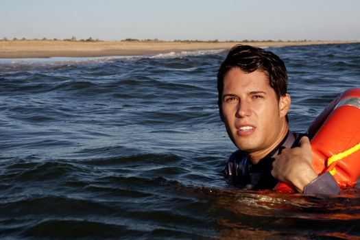Business man holds a lifesaver buoy on the water.