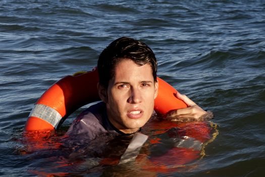 Business man holds a lifesaver buoy on the water.