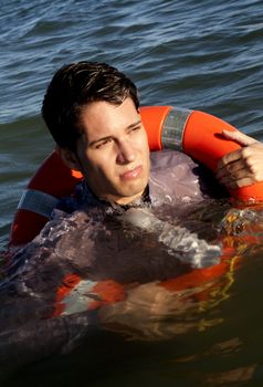 Business man holds a lifesaver buoy on the water.