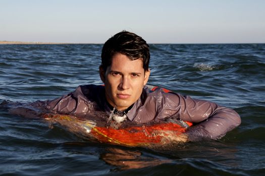Business man holds a lifesaver buoy on the water.