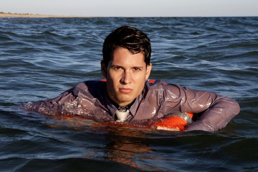 Business man holds a lifesaver buoy on the water.