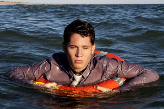 Business man holds a lifesaver buoy on the water.