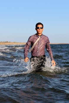 Fully dressed business man on the water .