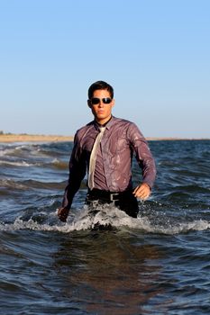 Fully dressed business man on the water .