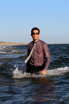 Fully dressed business man on the water .