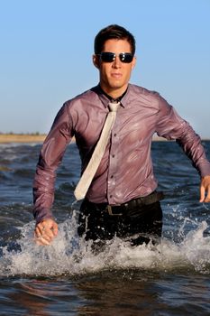 Fully dressed business man on the water .