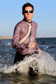 Fully dressed business man on the water .