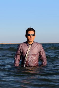 Fully dressed business man on the water .