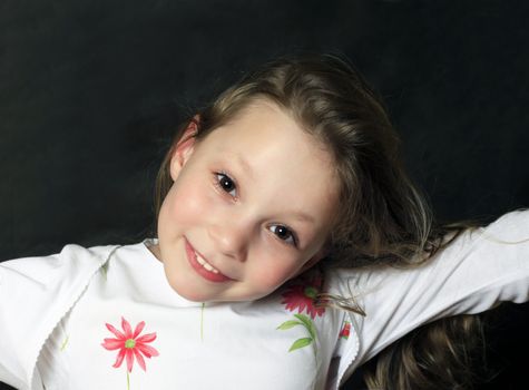 Portrait of young girl smiling on black background