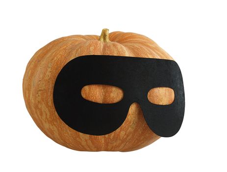 Small Halloween orange pumpkin in black   masquerade mask looking aside  isolated on white background