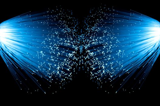 Two illuminated groups of blue fibre optic strands emanating from the left and right of the image. Black background.