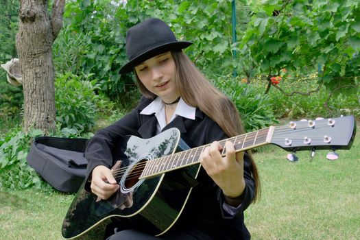 Girl playing the guitar in a park