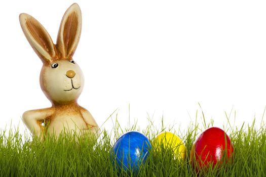 easter bunny behind grass with easter eggs on white background