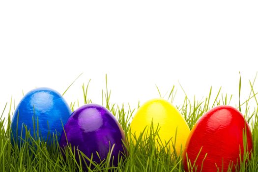 four easter eggs in grass with white background