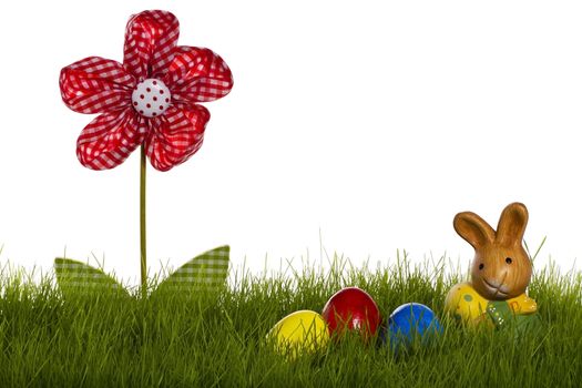 small easter bunny with easter eggs and drapery flower in grass with white background