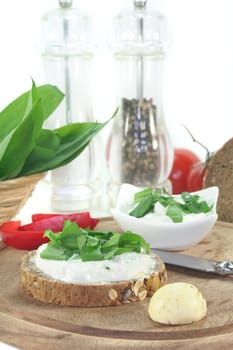 a slice of bread with cottage cheese and freshly chopped wild garlic