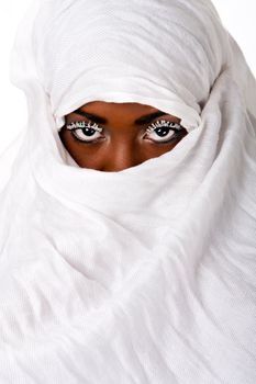 Beautiful female face in white scarf showing eyes with white lashes.