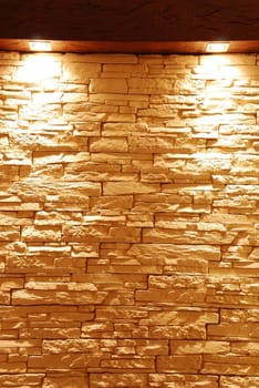 grey and unshaped stone wall with spot lights