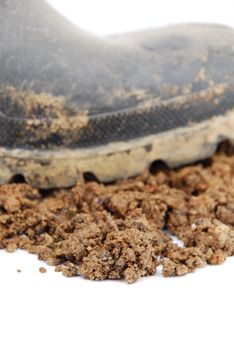 close-up on soil and one muddy farmer boot isolated on a white background