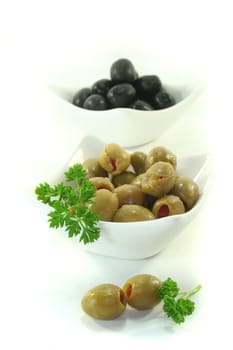 black and green olives with parsley on a white background