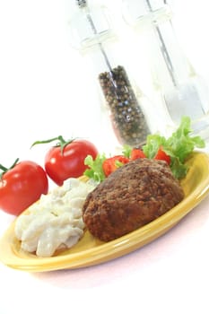 Meatball with potato salad, fresh lettuce and tomato pieces