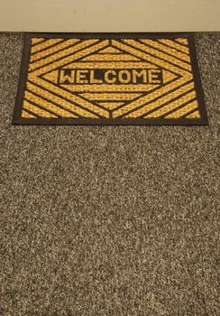 beautiful welcome home door mat on a grey carpet