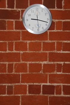 grey and white wall clock on a residential brick flat