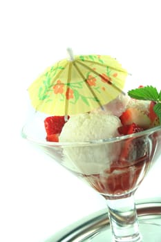 Strawberry ice cream on a silver tray and a fresh strawberry