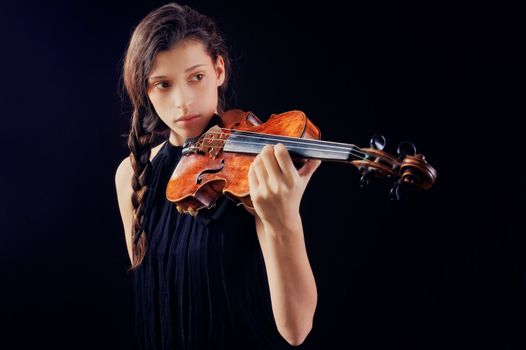 Young woman holding a violin. Isolated on the black background