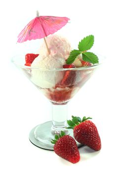 Strawberry ice cream on a silver dish and a fresh strawberry