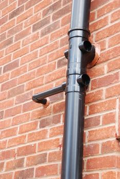 black tube on a brick house wall (used to drain water)