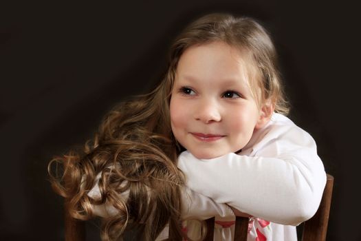 Portrait of young girl smiling on black background