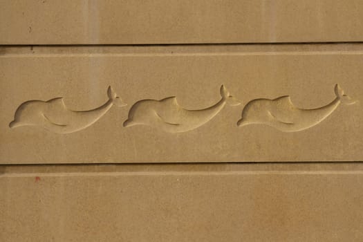 Sand coloured concrete cast panels with dolphin symbols in the centre