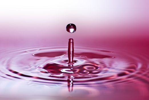 Red water environmental abstract background - red water drop splashing in clear clean water