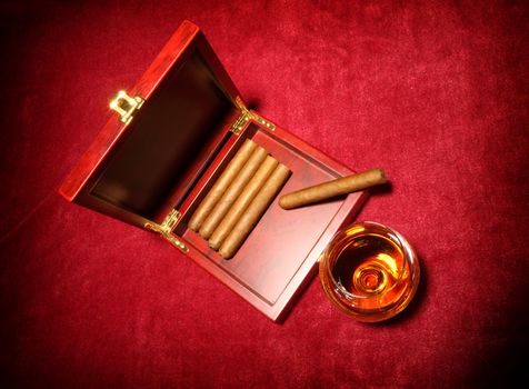 cigars in the box and glass with whisky, close up shallow dof 