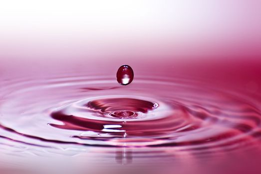 Red water environmental abstract background - red water drop splashing in clear clean water