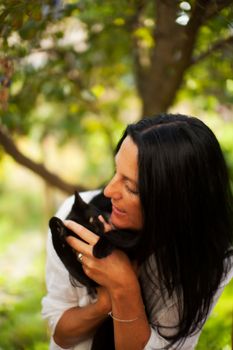 dark haired woman with a cat outdoor