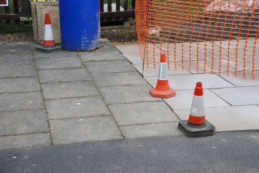 sidewalk construction site with orange cones and delimitation area