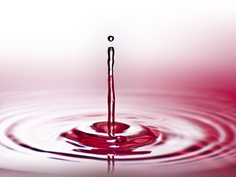 Red water environmental abstract background - red water drop splashing in clear clean water