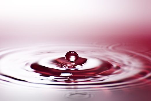 Red water environmental abstract background - red water drop splashing in clear clean water