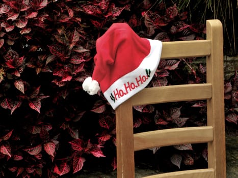 Christmas cap and chair on the background of leaves.