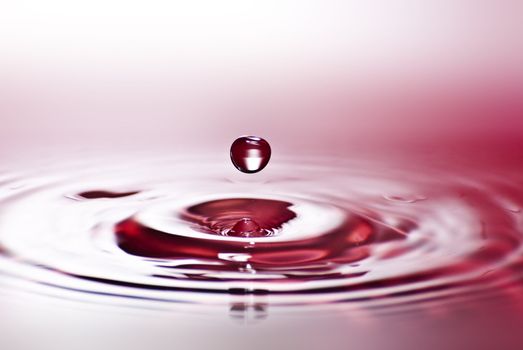 Red water environmental abstract background - red water drop splashing in clear clean water