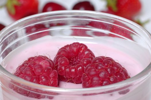 Three Rapsberries swimming in Yoghurt
