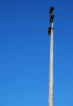 old electricity post in a small village (blue sky background)