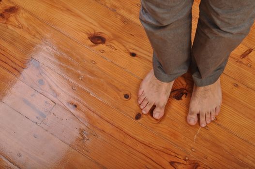 young man bare feet on wooden floor background