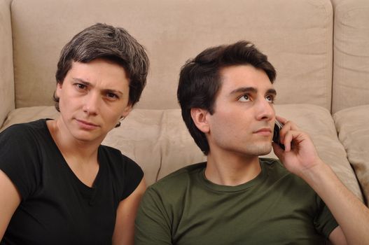frustrated woman being ignored by a man talking on the cell phone