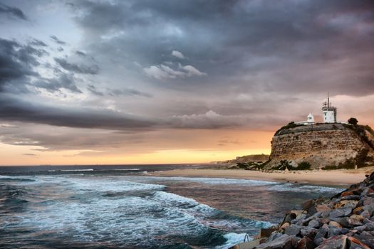 sunset on the ocean and lighthouse at newcastle