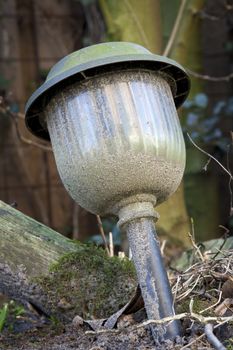 Old dirty lamp forgotten in the garden