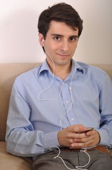 attractive young man listening to music on the couch